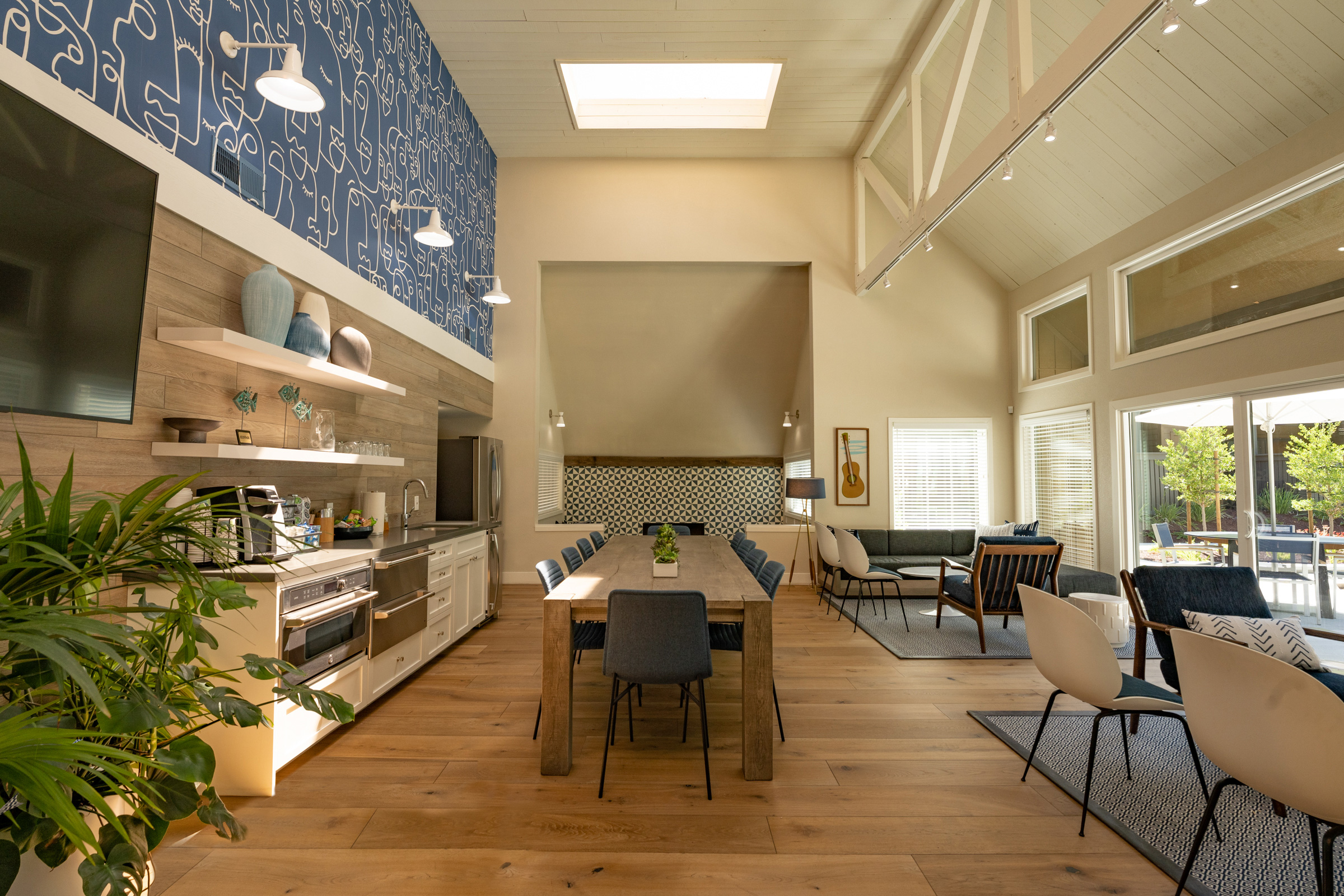 Kitchen with stove dishwasher and sink long wood table seating for 10 people.