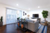 Living room with sliding glass patio door and shade blinds.