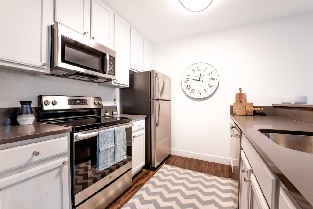 Stailess steel stove, dishwasher and refrigerator in kitchen.