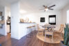 dinning area with table and chairs next to kitchen area, big clock on wall.