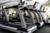 2 treadmills in front of a mirrored wall in gym.