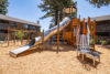 playground with long tubular metal slide and climbing structures