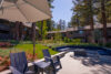 Modern metal fire pit surrounded by blue cushioned seating.