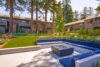 Modern metal fire pit surrounded by blue cushioned seating.